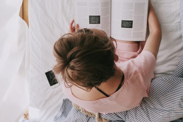 woman in pink dress sitting on bed while reading 698158 600x400 - Moms Need To Relax Too!